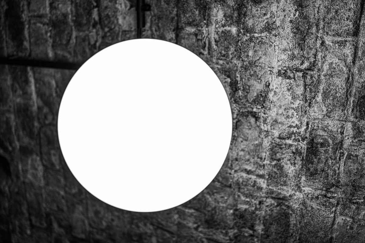 Weißer Lichtkreis vor rauer Wand – Motiv